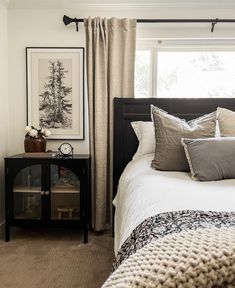 a bedroom with white walls and black furniture