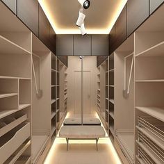 an empty walk in closet filled with lots of white shelves and shelving unit lights