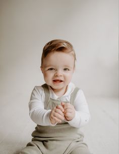 a baby is sitting on the floor and smiling