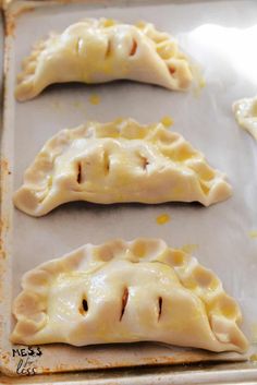 three uncooked dumplings sitting on top of a baking sheet