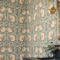 a bathroom with a sink, mirror and floral wallpaper on the walls next to it