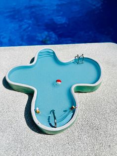 an odd shaped object sitting on the edge of a pool