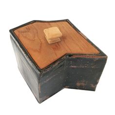 an old wooden box with a piece of cheese in it's lid on a white background