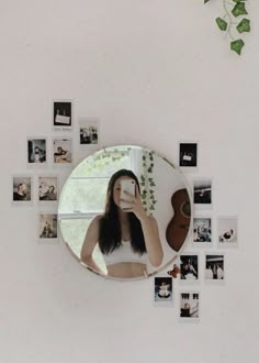 a woman taking a selfie in front of a mirror with photos on the wall