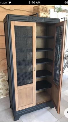 an open cabinet sitting on top of a tiled floor