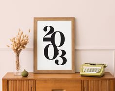 a framed poster with the number twenty three on it next to an old typewriter