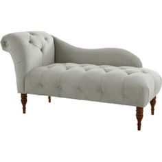 a light blue chaise lounger with wooden legs and tufted upholster