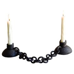 two candles are chained to chains on a white background