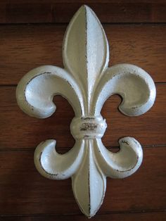 a white fleur de lis on a wooden surface