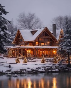 a large house with christmas lights on the front and trees around it in the snow