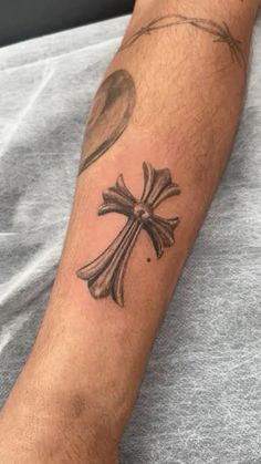 a man with a cross tattoo on his arm