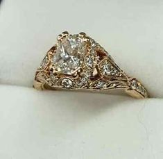 a fancy diamond ring sitting on top of a white cloth