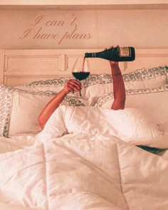 a woman laying in bed with a glass of wine