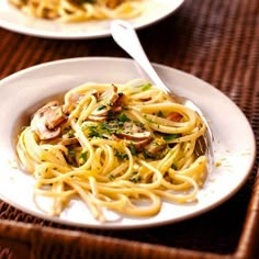 two white plates filled with pasta and mushrooms