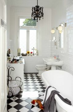 a black and white checkered floor in a bathroom with a chandelier hanging from the ceiling