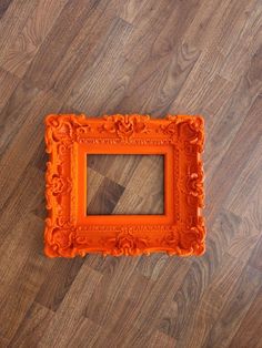 an orange frame sitting on top of a wooden floor