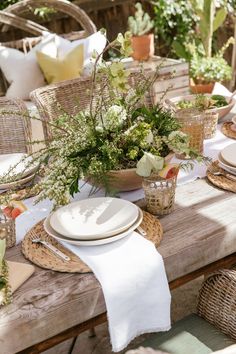 a table set with plates and flowers on it