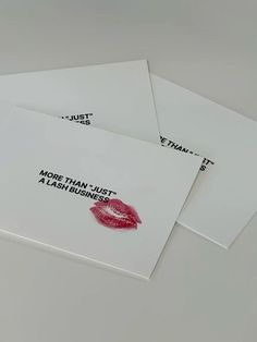 three white envelopes with red lipstick prints on them, one has the words more than just a flash business