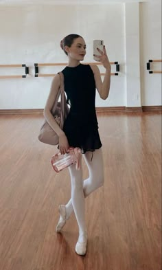 a woman is taking a selfie with her cell phone in an empty dance studio