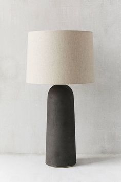 a black table lamp with a white shade on it's base and a beige linen lampshade