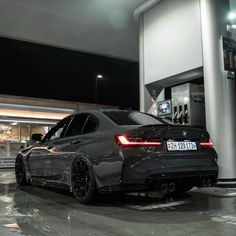 a black car parked in front of a gas station