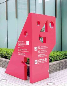 a large pink sculpture sitting in front of a building