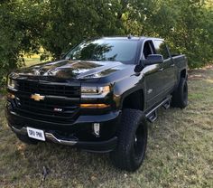 a black truck is parked in the grass