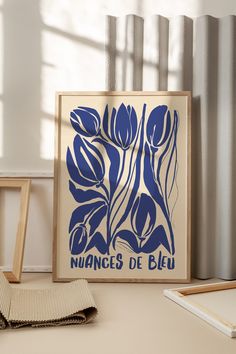 a blue and white flower print sitting on top of a table next to a window