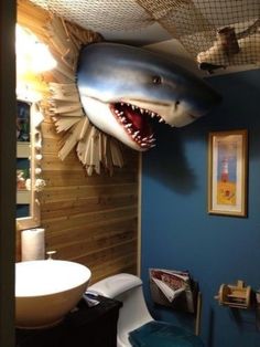 a bathroom with a shark head hanging from the ceiling