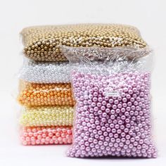 four bags of beads in different colors and sizes