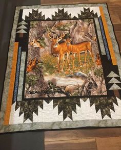 a quilt with deer on it is laying on the floor