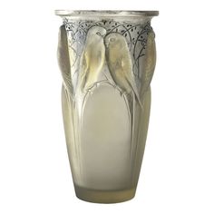 a glass vase with two birds on it