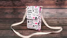 a white bag with pink hearts on it sitting on top of a wooden table next to a