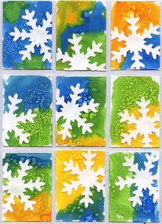 snowflakes are painted in different colors and sizes on glass blocks with watercolors