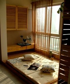 a bed room with a neatly made bed next to a window and wooden shutters