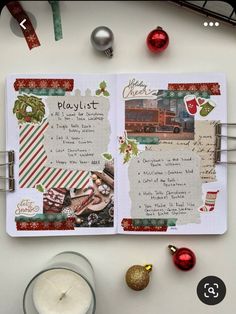 an open christmas scrapbook on a table next to candles and other holiday decor items