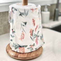 a roll of toilet paper sitting on top of a wooden stand