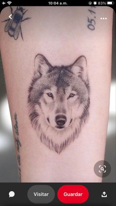 a tattoo on the leg of a woman with a wolf head and bees around her