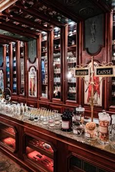 an old fashioned bar with many bottles and glasses on it's display shelves in a store