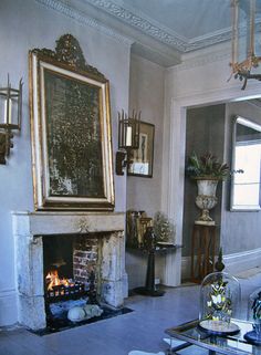 a living room filled with furniture and a fire place in the middle of the room