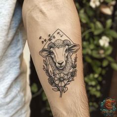 a man's arm with a tattoo on it that has a sheep and flowers