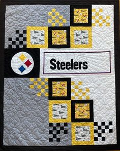 a quilt with the word steeles on it and squares in black, yellow and white