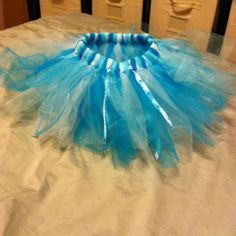 a blue tutu skirt sitting on top of a bed