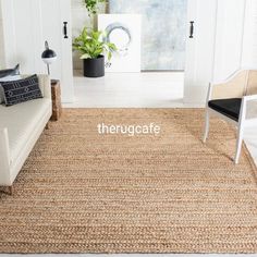 a living room with white walls and rugs