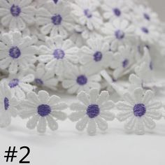 white and purple crochet flowers on a white surface