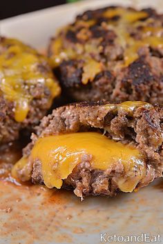 two hamburger patties covered in cheese on a plate