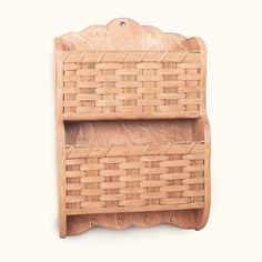 a wooden shelf with two baskets on the top and one shelf below it, against a white background