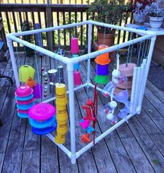 an outdoor play structure made out of plastic cups, toys and other items on a wooden deck