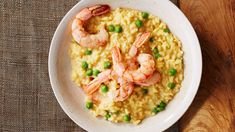 a bowl filled with rice and shrimp on top of a wooden table