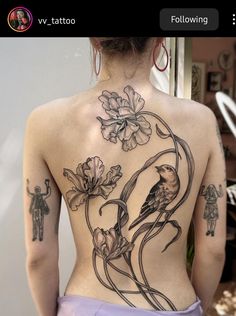 the back of a woman's body with flowers and birds tattooed on her chest